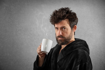 Man in bathrobe with funny hair cup of coffee isolated background