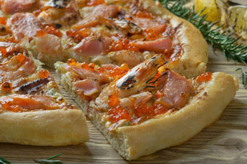 pizza with seafood and lemon on a wooden background