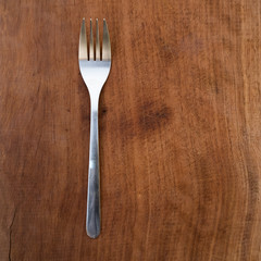 fork and knife on wooden background