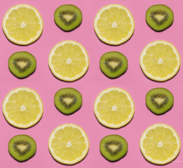 Fruit pattern. Slices of lemon and kiwi fruit on pink background