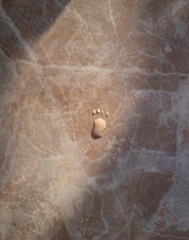 random water drops in a shape of a footprint on a marble countertop