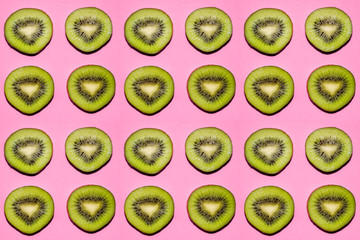 Fruit pattern. Slices of kiwi fruit on pink background