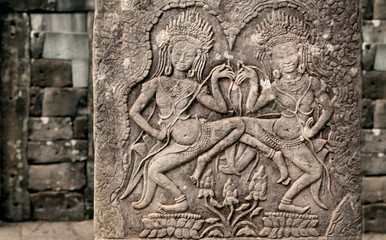 Columns with dancing women inside 12th century Bayon temple, Cambodia. Ancient artwork on wall of Khmer landmark in Angkor. UNESCO world heritage site