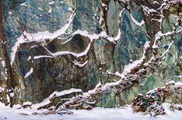 Colorful rock wall with snow on the ledges