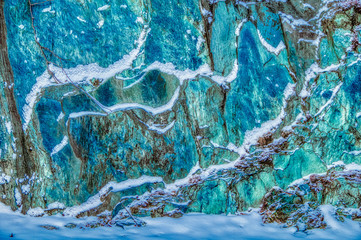 Colorful rock wall with snow on the ledges
