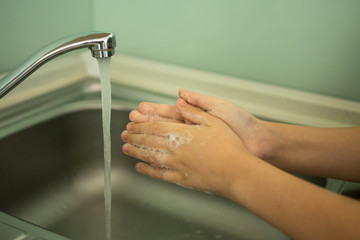 child washes his hands