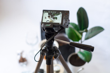 Recording video on the camera on tripod of coffee preparation process on white background.