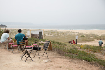 Nazaré, Portugal: Männer beim Picknick und Grillen oberhalb des berühmten Surfer Strandes Praia do Norte