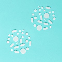 Pharmaceutical medicine pills, tablets lie on blue surface in form of round molecule, virus, or bacteria. Health care. Medical background and pattern.