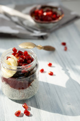 Fresh pomegranate berries, banana and sunflower seeds in chocolate granola to chia pudding with yogurt.