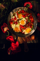 Fried egg in s pan with pepper and arugula. Morning breakfast. The warm harsh sunlight in the morning through the window.