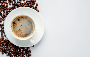Cup of coffee and coffee beans on a white background with copy space for your text.