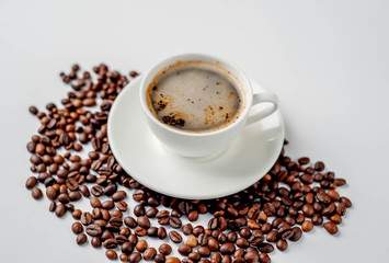 Cup of coffee and coffee beans on a white background with copy space for your text.