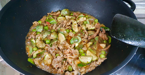 Jungle curry with pork boiling in pan,Thai recipe-gaeng pa moo,Spicy red herbal curry with pork against the covid-19,Fnger root, basil,Egg plant,Turkey berry,Kaffir lime leaves, pepper and chili, Thai