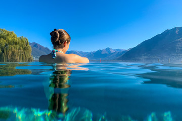 Junge Frau entspannt beim Wellness in den Bergen in einem schönen Pool