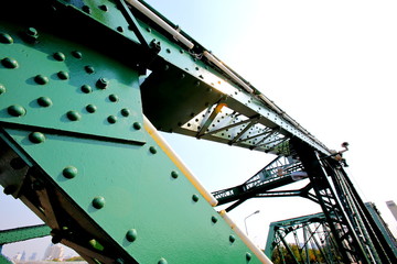 A beautiful old green bridge with steel structures.