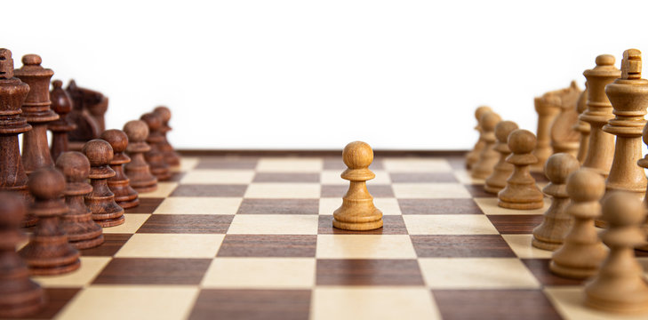 Chess pieces lined up on the chessboard with pawn moved. Concept picture concerning decision making and strategy.
