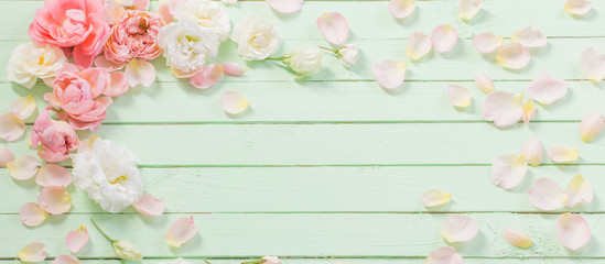 pink and white roses on green wooden background