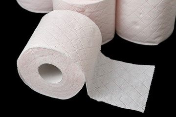 rolls of toilet paper piled on black background
