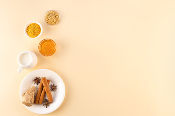 Ingredients for making Golden milk on a beige background. Masala Haldi Doodh. The concept of alternative medicine