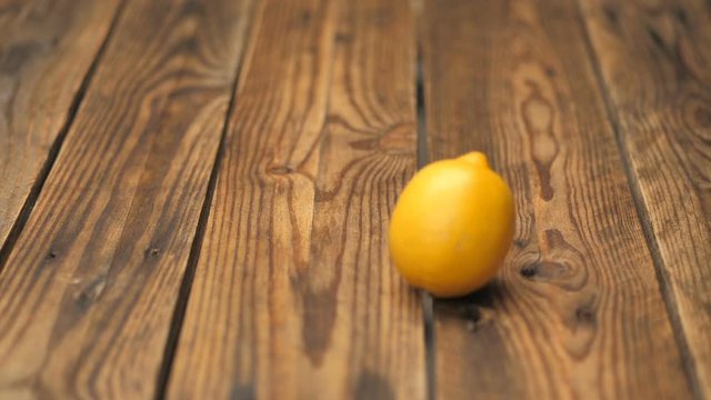 Lemons on a wooden table. A beautiful table top made of fruit and limes. Hands throw them into place. Fresh hipster climate. Tasty view as a background for advertising. Look at my channel for similar.