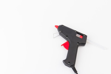 Electric hot glue gun on gray background. Rods for glue gun