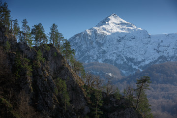 Winter mountain snow peak forest view. Beautiful landscape of mountain ranges of the Caucasus Mountains in the Krasnaya Polyana region of Sochi, Russia