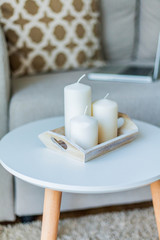 Beautiful stylish interior. The laptop is on the couch, pillow, candles. The cozy corner of the apartment.