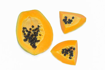Three sliced pieces of fresh yellow ripe papaya fruit isolated before a white background