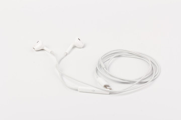 White headphones for listening to music and sound on portable devices: music player, smartphone, laptop and jack for connection on a white background.