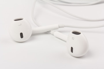 White headphones for listening to music and sound on portable devices: music player, smartphone, laptop and jack for connection on a white background.