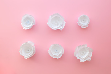 Handmade paper art and cut white flowers on pink background. 