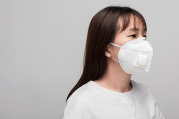 Young woman with face mask isolated on white background to prevent coronavirus & PM 2.5 air...