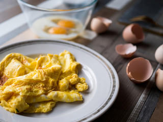 process of making omelet from natural eggs and products. Milk, salt, eggs. Cup for whipping omelet. Fork and knife. Frying pan and oil