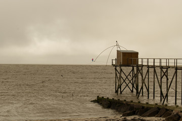 Fototapeta na wymiar Les Moustiers en Retz en Loire atlantique kitesurf par tous les temps et pêche au carrelet au bout d'un ponton sur la côte et le rivage