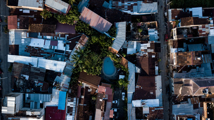 Aerial top view of Tarapoto city in the peruvian jungle. Swimming pool, buildings, trees from above during sunset