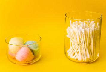 cotton swabs, colored cotton wool ball, cotton discs inside glass small container with wooden top....