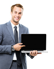 Smiling attractive businessman in grey confident suit, showing blank laptop monitor, isolated against white background, with copy space area for some slogan, imaginary, ad or text.