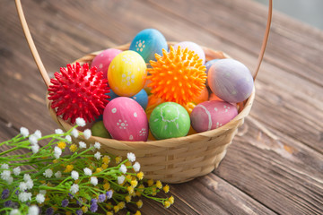 Virus model of Coronavirus disease COVID-19 with colorful easter eggs in basket with flowers on a wooden table background