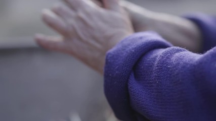 Side view close-up of old female hands cutting off potato sprouts. Unrecognizable elderly Caucasian woman harvesting vegetables in the autumn. Healthy homegrown food, rural lifestyle, agriculture.