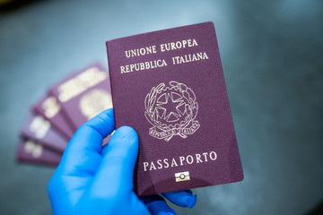 hand with sterile glove holding electronic passports of the european union and italian republic