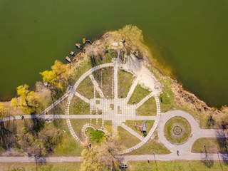 Footpaths in the park near the green lake. Aerial drone view.