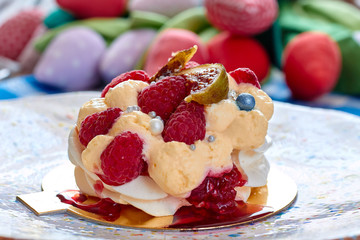Dessert Pavlova with raspberries and figs on plate. Dessert Pavlova and figs and tulips on a rustic background.