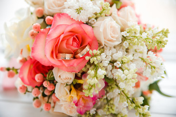 Wedding pink delicate bouquet of roses with rings.