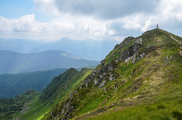 The nice view to the landscape of high mountain Pip Ivan in the cloudy day is opened from the green valley covered with bushes and pathway. Location the Carpathian Mountains, Marmarosy, Ukraine.