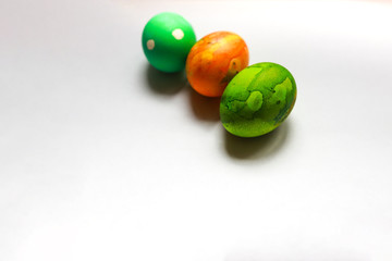 three easter eggs painted by child abstact messy painting orange and green vibrant colors