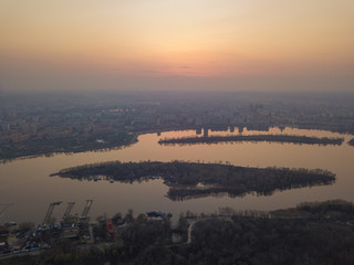 Fototapeta premium Sunset over the Dnieper River in Kiev. Aerial drone view.