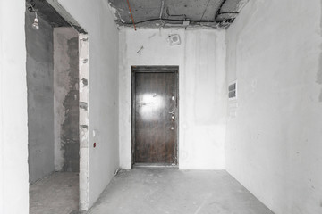 interior of a new apartment without finishing in gray tones with electrical wiring