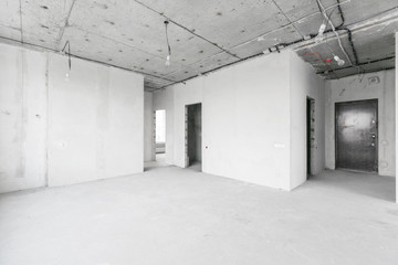 interior of a new apartment without finishing in gray tones with electrical wiring