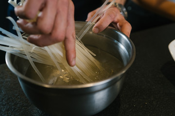 Rice noodles in a bowl with hot water for cooking
